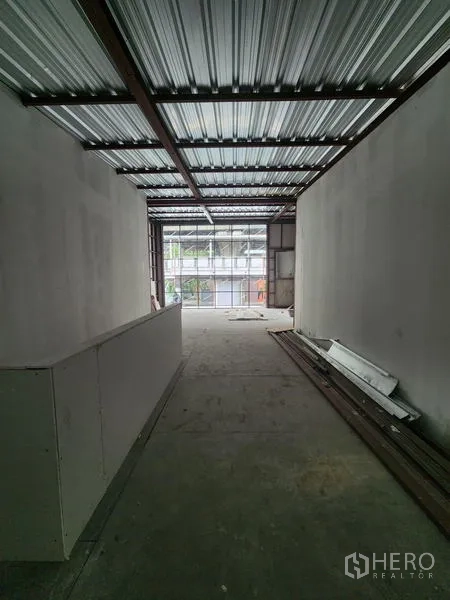 Retail Space for rent in Khlong Toei, Bangkok - Long bare-shell interior with metal roof, white walls, concrete floor, and daylight from full-height glazing.