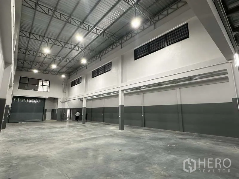 Factory for rent or sale in Bang Bua Thong, Nonthaburi - Bright, high-ceiling warehouse with ventilated side windows and two-tone walls.