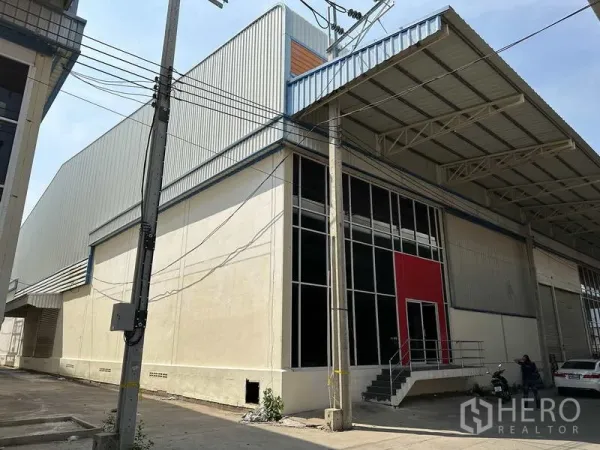 工厂 出租在Bang Phli, Samut Prakan - 工厂转角外观，钢板墙体、通高窗与带顶装卸区。