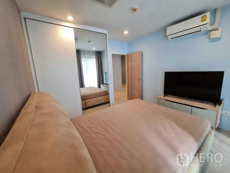 公寓 出租在Pathum Wan, Bangkok - 次卧带镜面移门衣柜、壁挂空调、床与低柜电视。