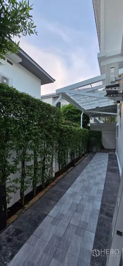 独立式住宅 出租在Samut Prakan - 侧边铺砖步道，带雨棚与绿篱