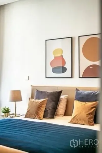 公寓 出租在Bang Rak, Bangkok - 温馨卧室，挂有现代装饰画与蓝色床品