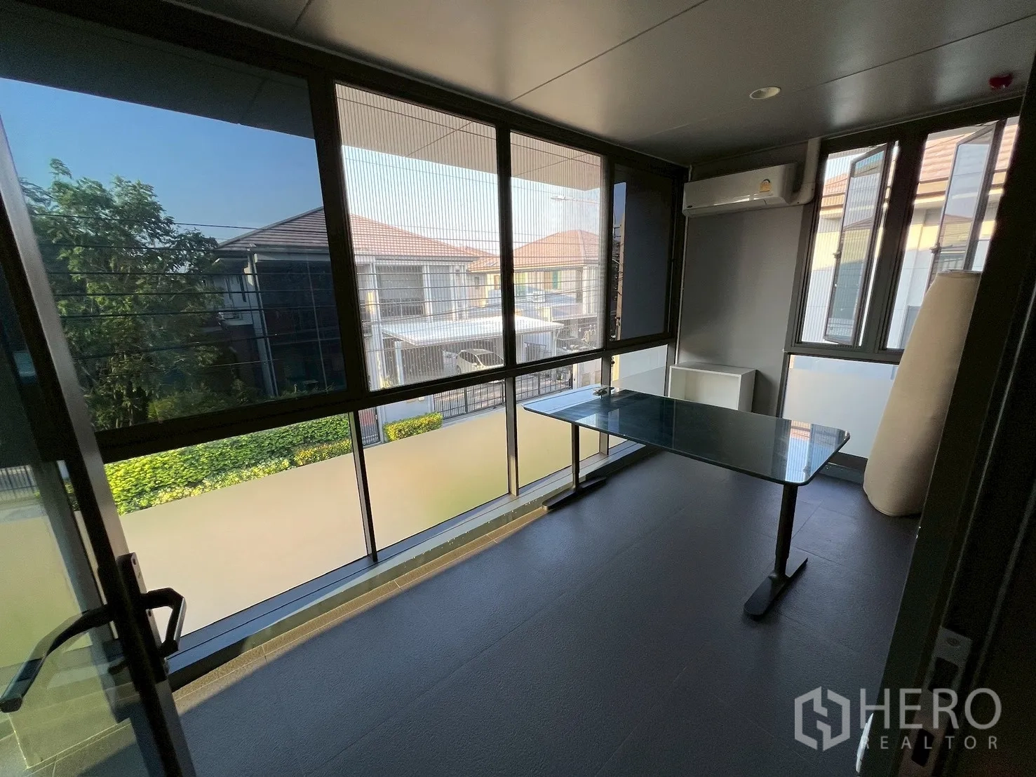 Detached House for rent in Bang Kapi, Bangkok - Enclosed balcony or sunroom with full-height windows and air conditioner.