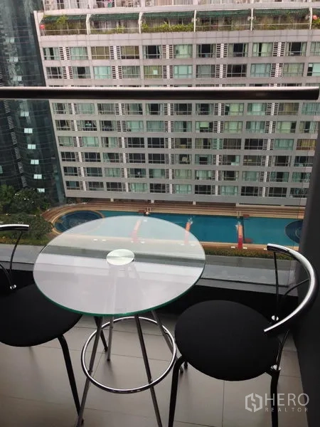 คอนโด ให้เช่าในWatthana, Bangkok - ระเบียงกะทัดรัด โต๊ะกระจกทรงกลมกับสตูลสองตัว มองเห็นสระว่ายน้ำและอาคารพักอาศัย