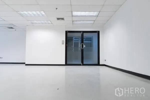 办公空间 出租在Ratchathewi, Bangkok - 现代白色办公室的双开玻璃门，吊顶与明亮照明。