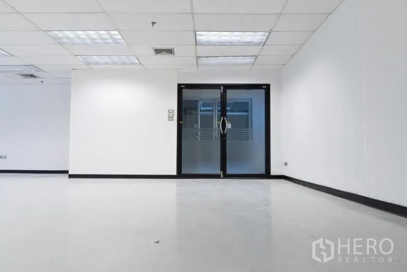 办公空间 出租在Ratchathewi, Bangkok - 现代白色办公室的双开玻璃门，吊顶与明亮照明。
