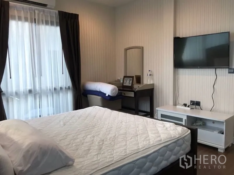 บ้าน ให้เช่าในBang Kapi, Bangkok - ห้องนอนพร้อมเตียง ทีวีติดผนัง และโต๊ะเครื่องแป้งข้างหน้าต่าง