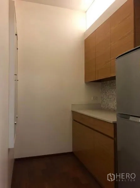 Townhouse for rent in Chatuchak, Bangkok - Compact pantry kitchen with wood cabinetry, solid countertop and refrigerator.