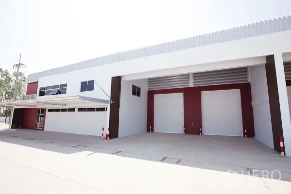 Factory for rent in Si Racha, Chon Buri - Front elevation showing covered loading bays and multiple roll-up shutters.