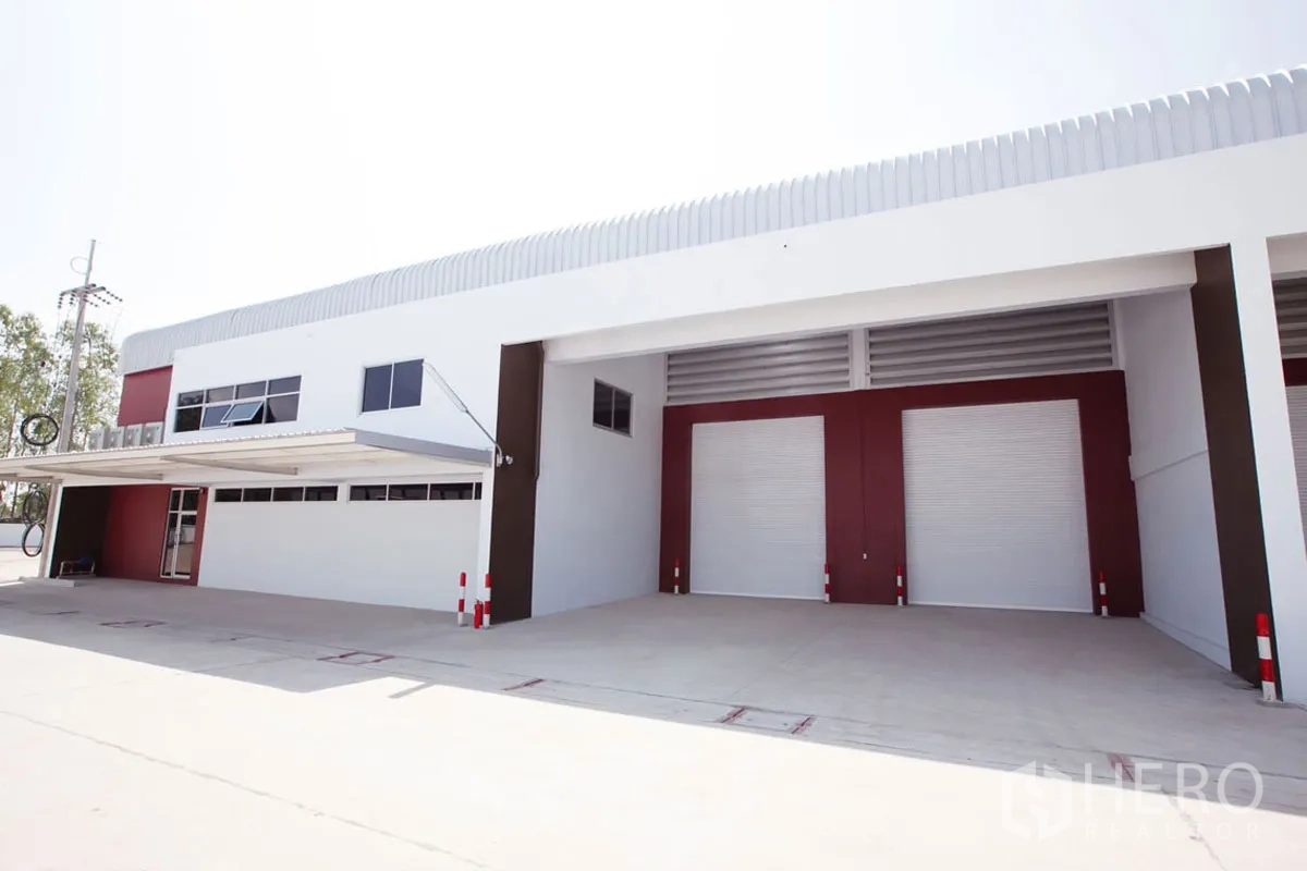 Factory for rent in Si Racha, Chon Buri - Front elevation showing covered loading bays and multiple roll-up shutters.