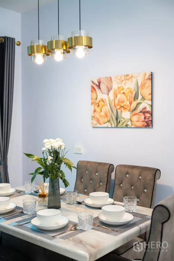Townhouse for rent - Close-up of marble dining table with gold pendant lights and floral wall art