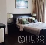 Condominium for rent in Watthana, Bangkok - Master bedroom with upholstered bed, bedside lamps and full-height curtains.