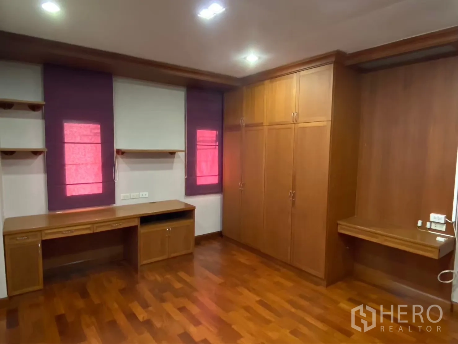 Detached House for rent in Watthana, Bangkok - Bedroom with built-in desk, wardrobe and wooden flooring.