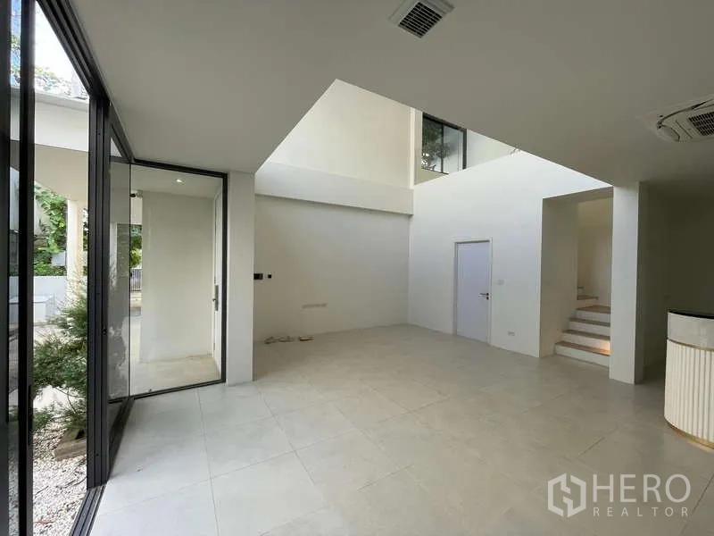 Home Office for rent in Don Mueang, Bangkok - Ground-floor lobby with double-height ceiling and sliding glass doors to garden.