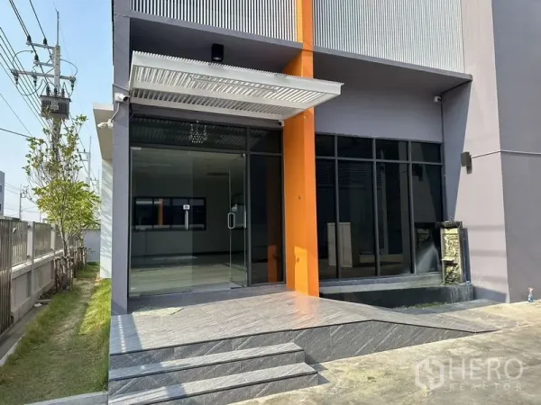 工厂 出租或出售在Lam Luk Ka, Pathum Thani - 办公楼主入口特写，玻璃门、雨篷与台阶。