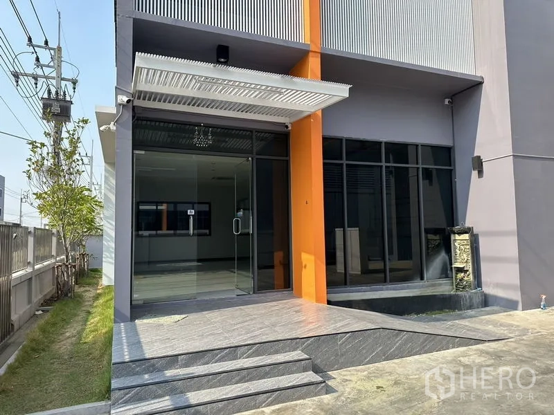 工厂 出租或出售在Lam Luk Ka, Pathum Thani - 办公楼主入口特写，玻璃门、雨篷与台阶。