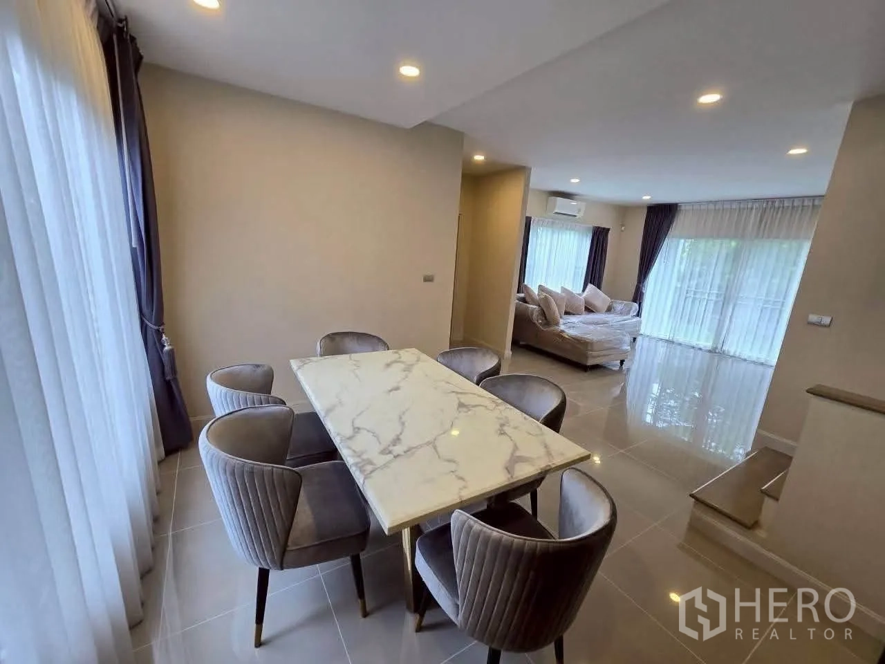 独栋房屋 for rent or sale in Lat Krabang, Bangkok - 餐厅与客厅相连，可见沙发与大窗。