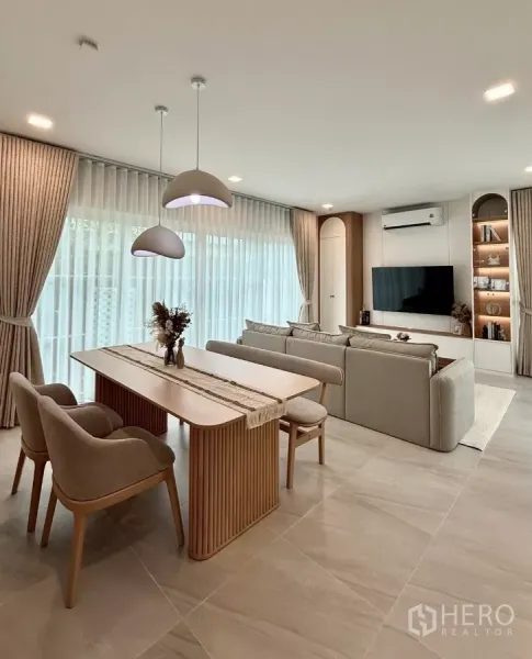 Detached House for rent in Bang Phli, Samut Prakan - Open-plan dining and living room with pendant lights, sheer curtains and TV feature wall