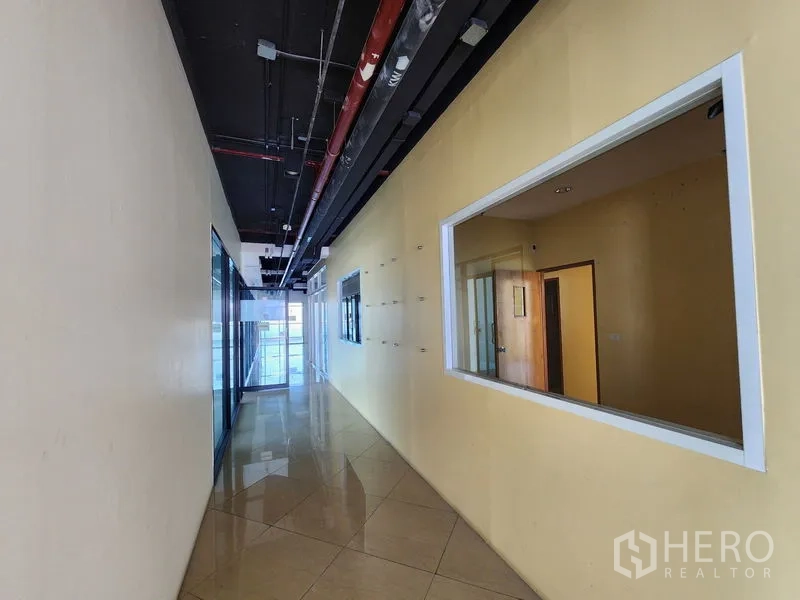 Retail Space for rent in Bang Rak, Bangkok - Long passage with display window, polished tiles, and black ceiling.
