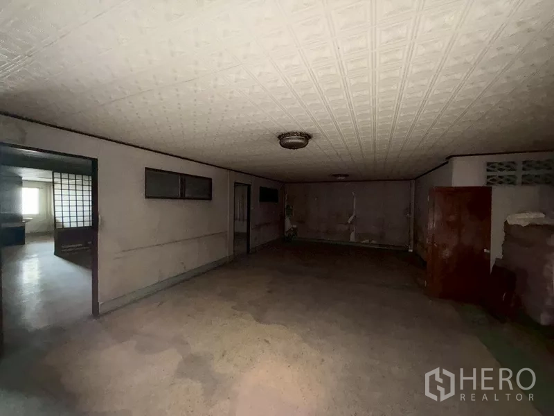 Shophouse for rent - Dim room with classic ceiling panels and built-in cabinetry.