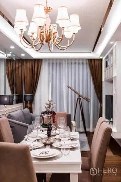 公寓 出租在Huai Khwang, Bangkok - 吊灯下的餐桌，落地窗帘与望远镜，毗邻客厅。