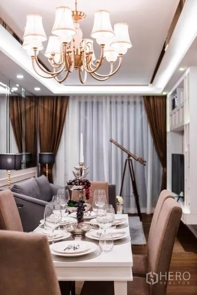 公寓 出租在Huai Khwang, Bangkok - 吊灯下的餐桌，落地窗帘与望远镜，毗邻客厅。