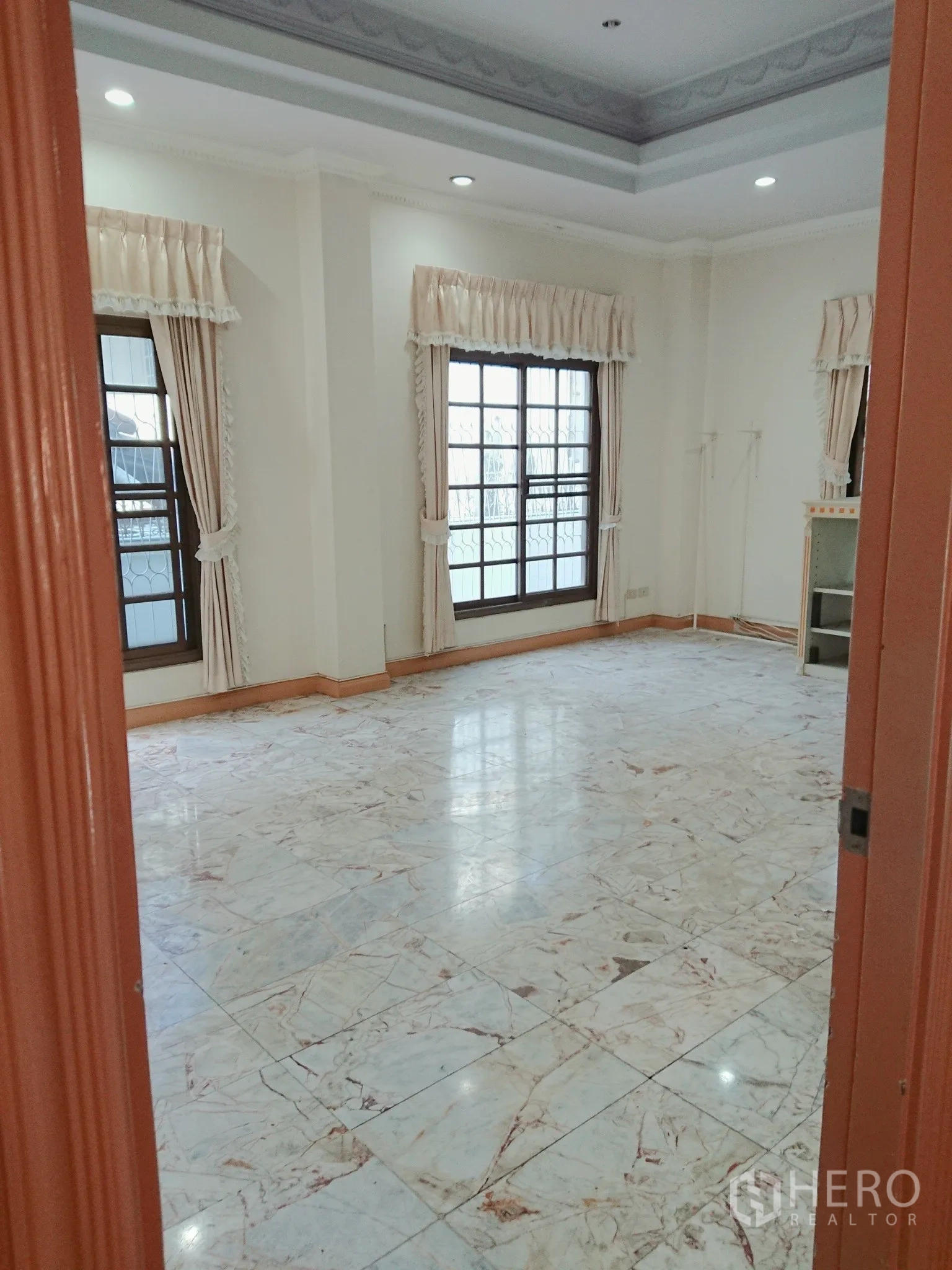 Detached House for sale in Chatuchak, Bangkok - Spacious bedroom with marble floors, recessed ceiling and curtained windows.