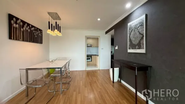 公寓 出售在Yan Nawa, Bangkok - 用餐区，白色餐桌与透明椅，现代吊灯，旁边通往厨房。