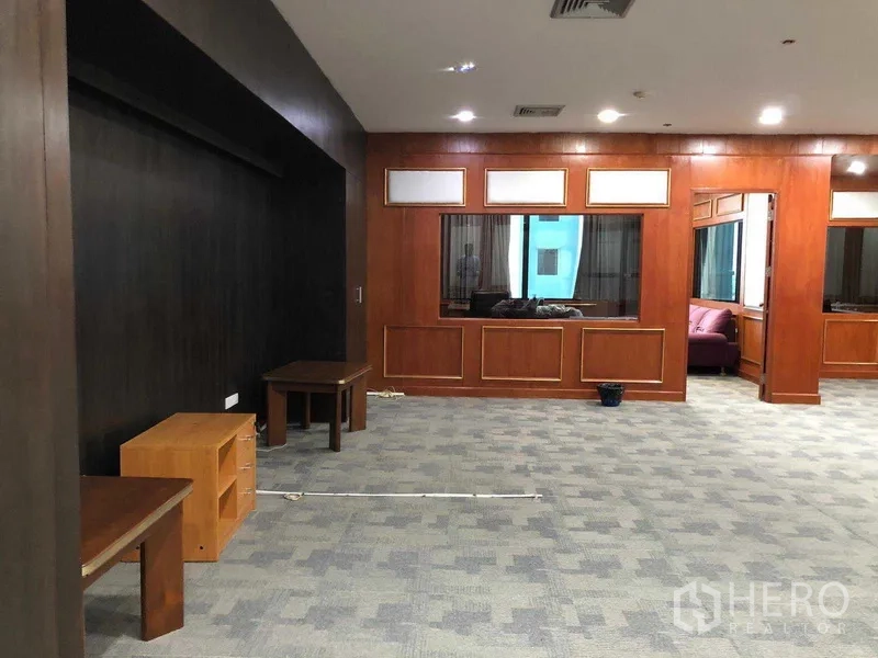 สำนักงาน ให้เช่าในRatchathewi, Bangkok - พื้นที่สำนักงานกว้าง พื้นพรม ผนังไม้ และหน้าต่างมองทะลุไปยังห้องข้างเคียง