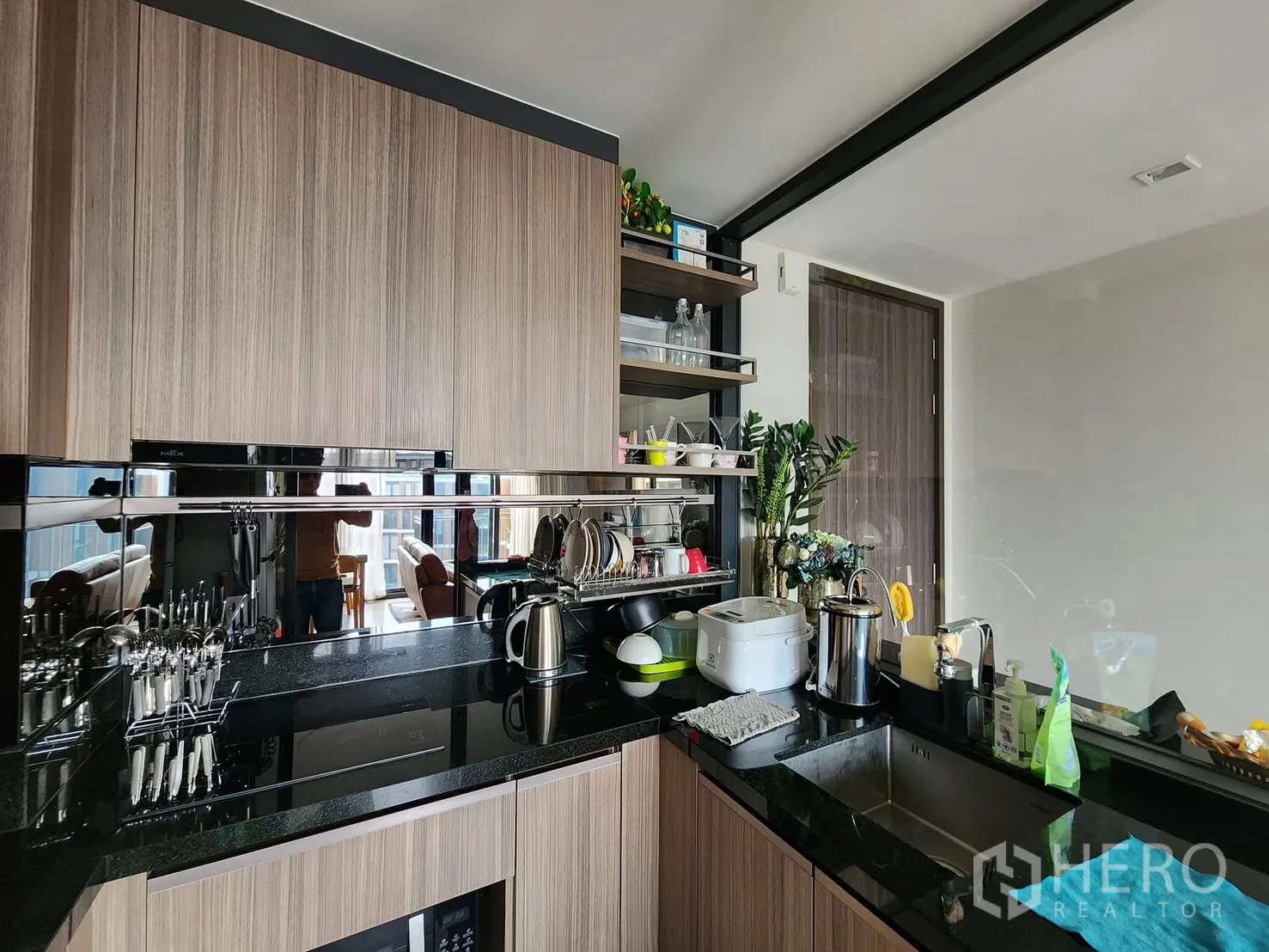 公寓 for rent in Watthana, Bangkok - 现代厨房，黑色花岗岩台面、木质柜体、不锈钢水槽与电磁炉。