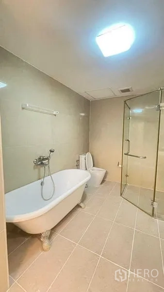 公寓 出租在Khlong San, Bangkok - 浴室设独立爪足浴缸与玻璃淋浴间，地砖铺设。