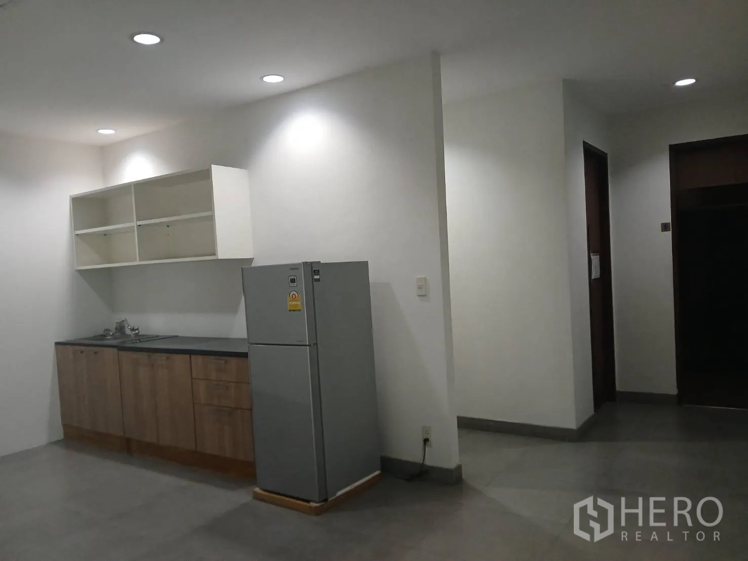 Factory for rent or sale in Uthai, Phra Nakhon Si Ayutthaya - Staff pantry with upper shelves, base cabinets, sink and a refrigerator under recessed lighting.