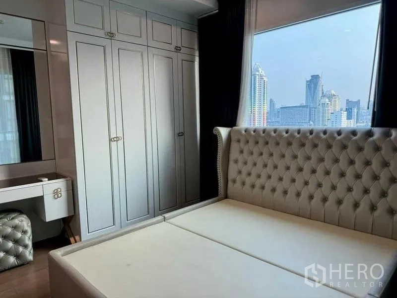 公寓 出售在Ratchathewi, Bangkok - 卧室带嵌入式衣柜、梳妆区和城市景观窗。