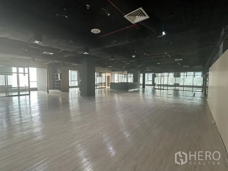 Office Space for rent in Bang Rak, Bangkok - Expansive office floor with exposed black ceiling and wide perimeter windows.