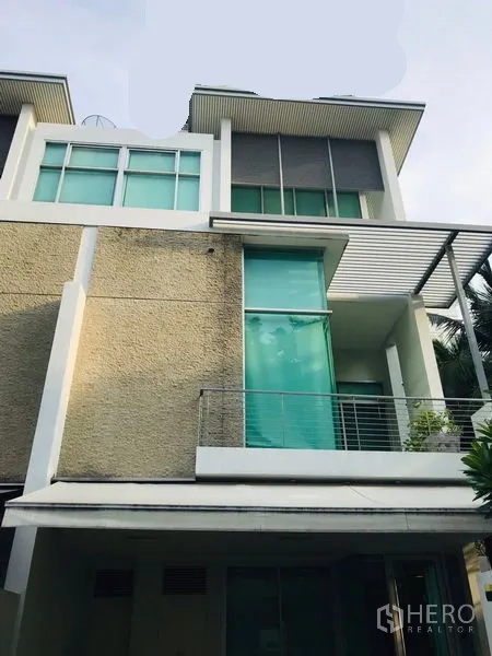 Townhouse for rent or sale in Chatuchak, Bangkok - Contemporary townhouse exterior showing balcony, tall windows and textured facade.