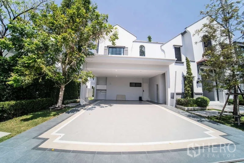 Detached House for rent in Saphan Sung, Bangkok - Covered two-car carport with wide driveway and surrounding greenery.