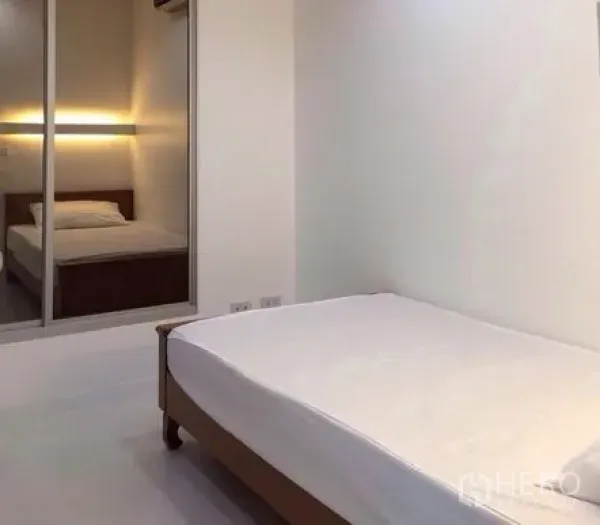 公寓 出租在Bang Rak, Bangkok - 第二卧室，极简风格，滑动镜面门映出床铺。