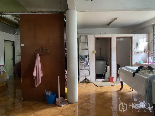 Shophouse for rent in Khlong Toei, Bangkok - Tiled multipurpose room with column, utility doors and cleaning tools.