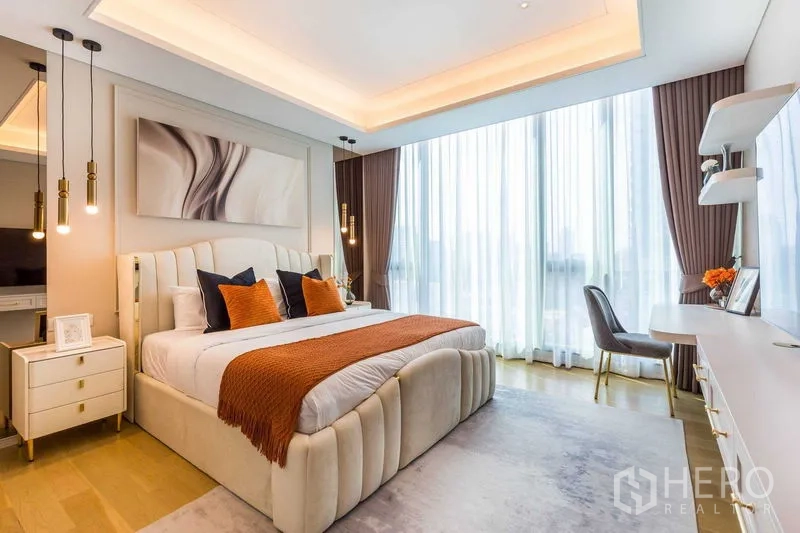 Condominium for sale in Pathum Wan, Bangkok - Primary bedroom with upholstered bed, pendant lamps and floor-to-ceiling windows with sheer curtains