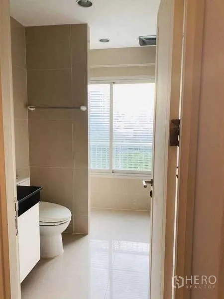 公寓 出租或出售在Watthana, Bangkok - 紧凑卫浴，设坐便、洗手台与大窗采光。