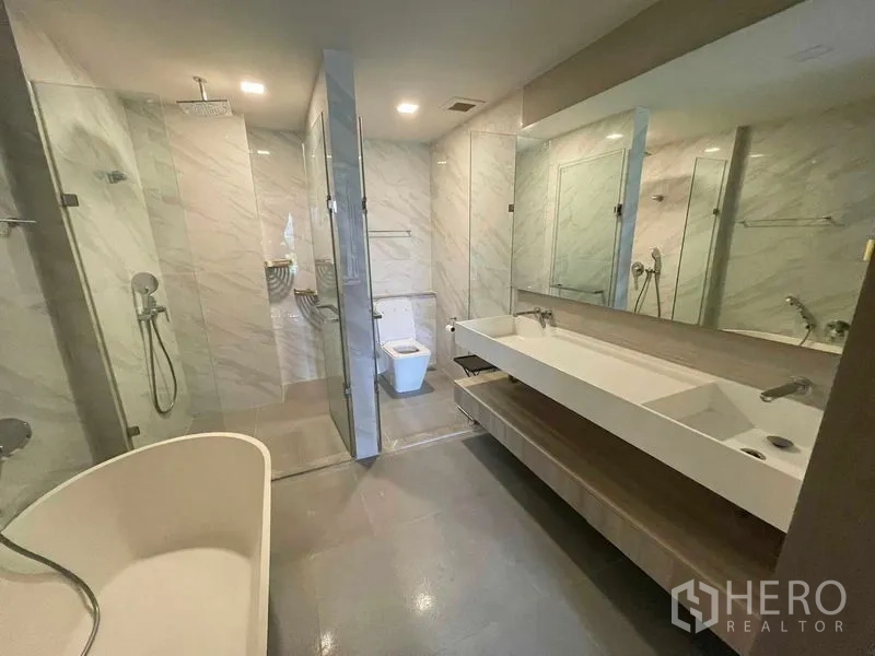 公寓 出租或出售在Watthana, Bangkok - 现代卫浴，双台盆、玻璃雨淋淋浴间与独立浴缸。