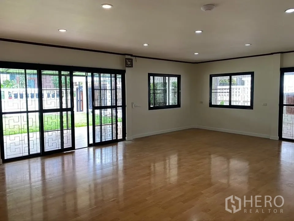 Detached House for rent in Suan Luang, Bangkok - Bright room with wood laminate flooring and sliding glass doors to the garden.