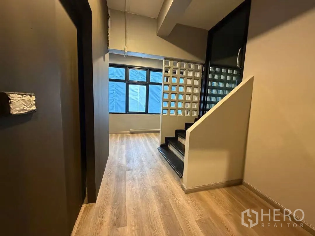 Home Office for rent in Watthana, Bangkok - Hallway with wood floors, glass block wall and stairs leading to upper level.