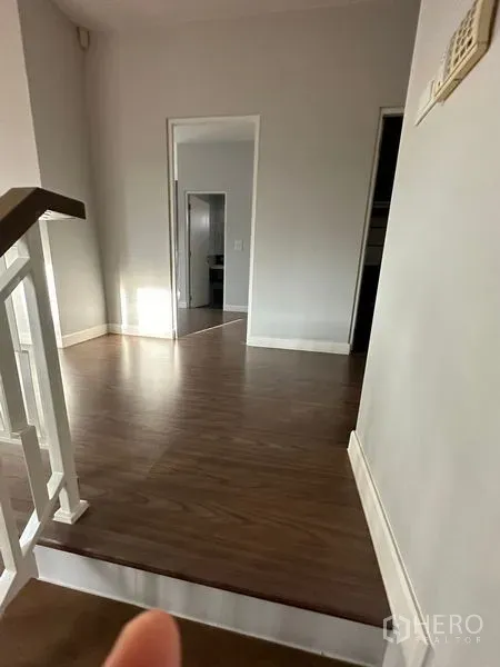 Detached House for rent or sale in Lam Luk Ka, Pathum Thani - Hallway with wood flooring and white trim leading to bedrooms.