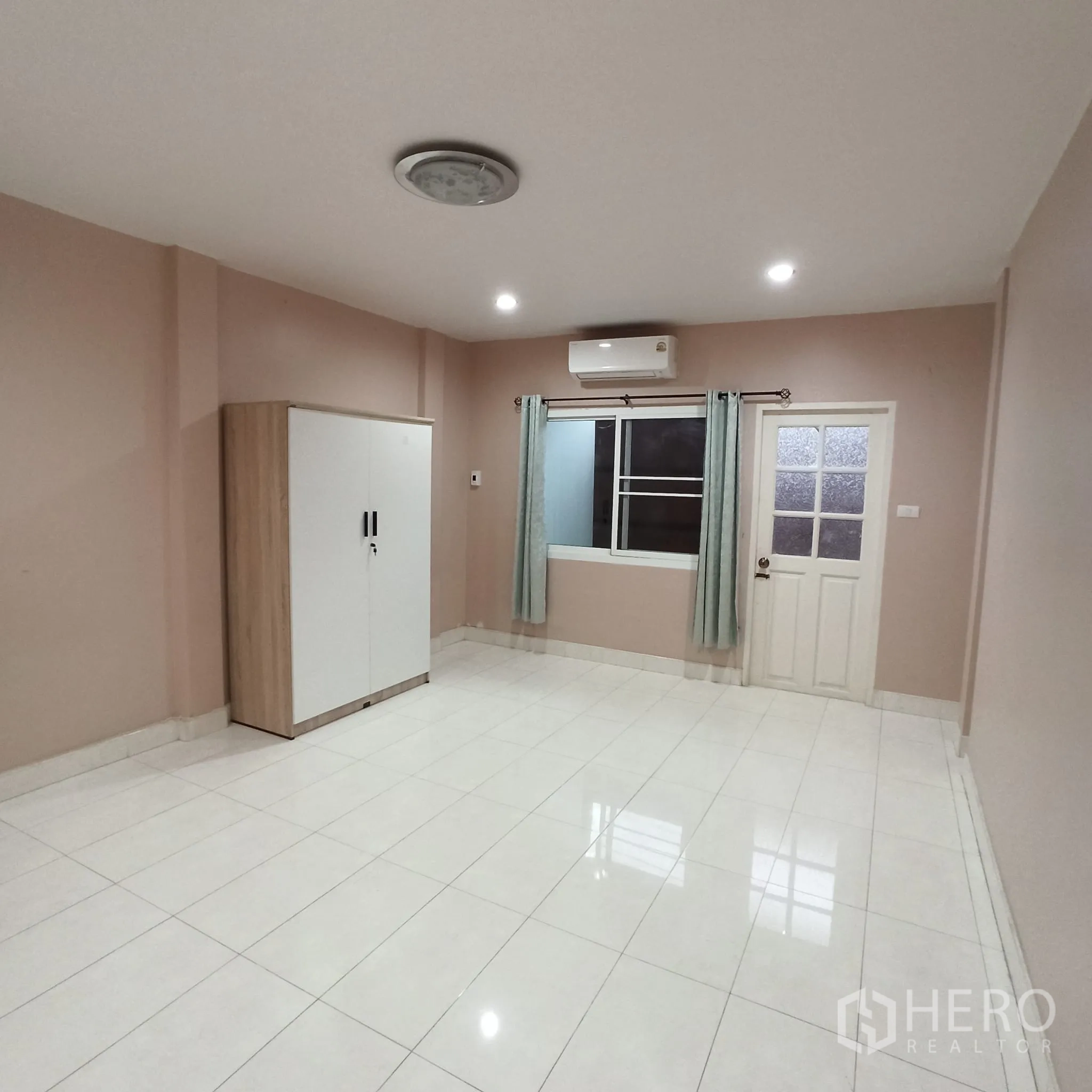 Townhouse for rent in Wang Thonglang, Bangkok - Second bedroom with neutral walls, wardrobe and window.