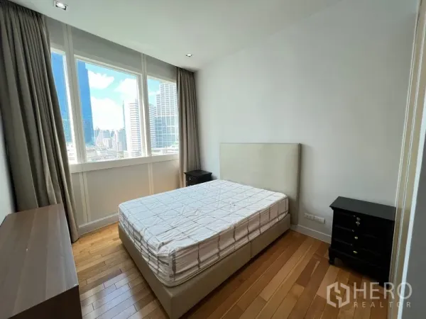 Condominium for rent in Khlong Toei, Bangkok - Guest bedroom with large window, city view and bedside tables.