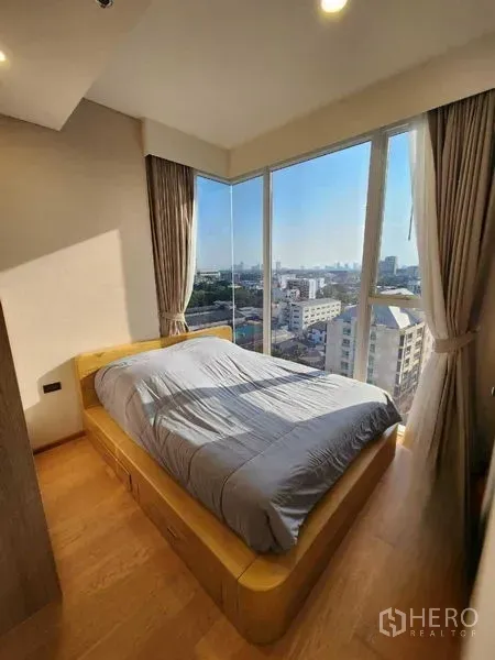 公寓 出租在Khlong Toei, Bangkok - 主卧落地转角窗，充足采光与城市景观