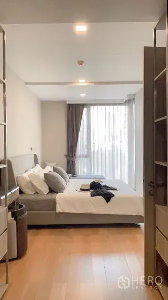 公寓 出租在Watthana, Bangkok - 采光良好的卧室，木地板、软包大床与落地窗帘。