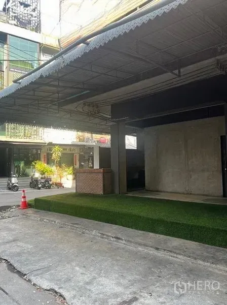 Retail Space for rent in Watthana, Bangkok - Street view of the retail frontage with deep awning and a ramped artificial grass forecourt.