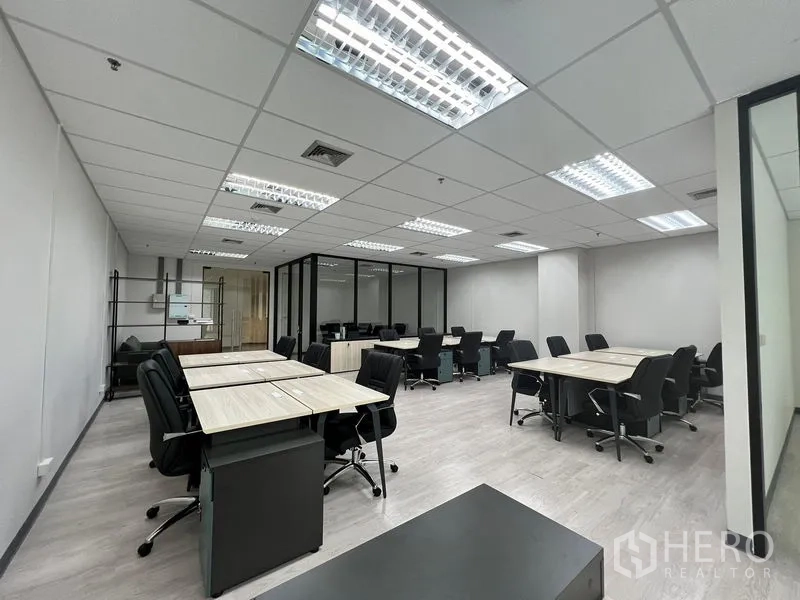 Office Space for rent in Sathon, Bangkok - Wide shot of a spacious office floor with ceiling lights, glass partitions, and multiple desks.